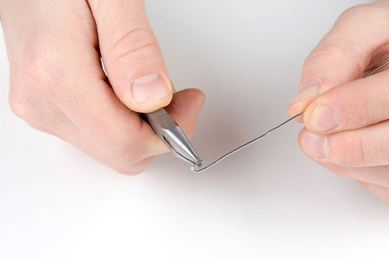 Straighten out paper clip/bend hook on one end